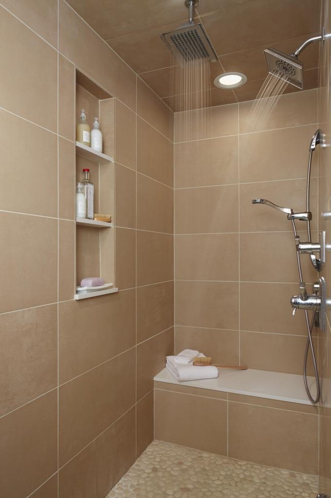 Photo of a contemporary bathroom in Detroit with beige tile, pebble tile floors and a niche.