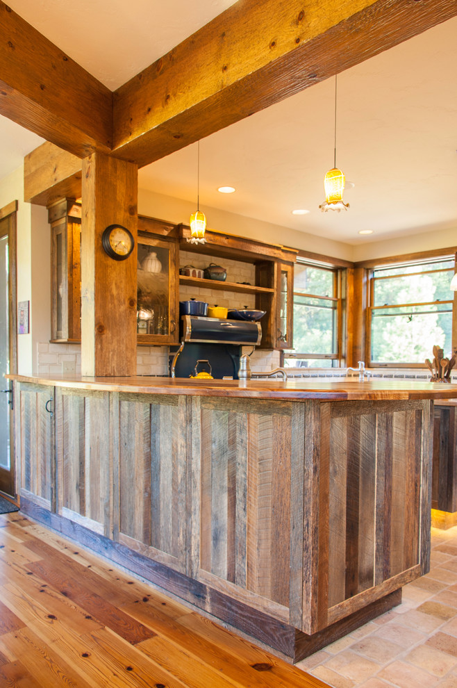 Example of a large mountain style u-shaped cement tile floor and beige floor open concept kitchen design in Seattle with recessed-panel cabinets, granite countertops, beige backsplash, ceramic backsplash, stainless steel appliances, an island, an undermount sink and dark wood cabinets