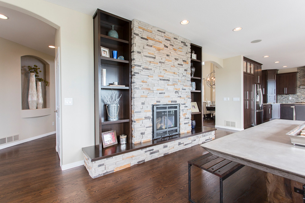 Inspiration for a large transitional l-shaped dark wood floor and brown floor great room remodel in Denver with an undermount sink, shaker cabinets, dark wood cabinets, granite countertops, metallic backsplash, glass tile backsplash, stainless steel appliances and an island