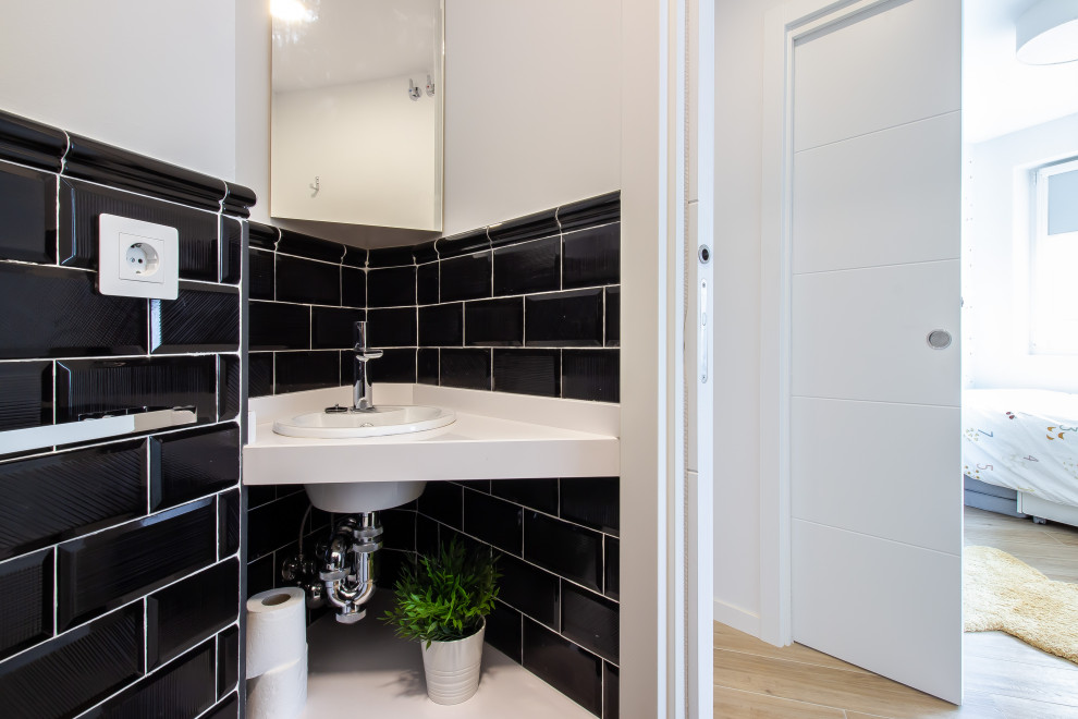 Стильный дизайн: туалет в скандинавском стиле с черно-белой плиткой, светлым паркетным полом, столешницей из искусственного кварца и подвесной тумбой - последний тренд