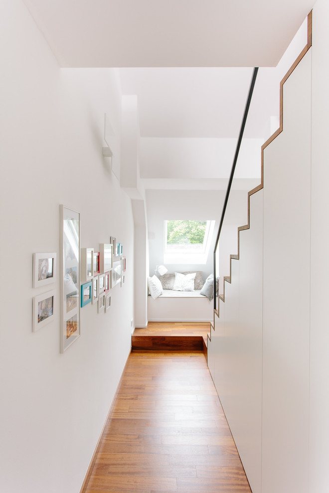 Kleiner Skandinavischer Flur mit weißer Wandfarbe, braunem Holzboden und braunem Boden in Köln