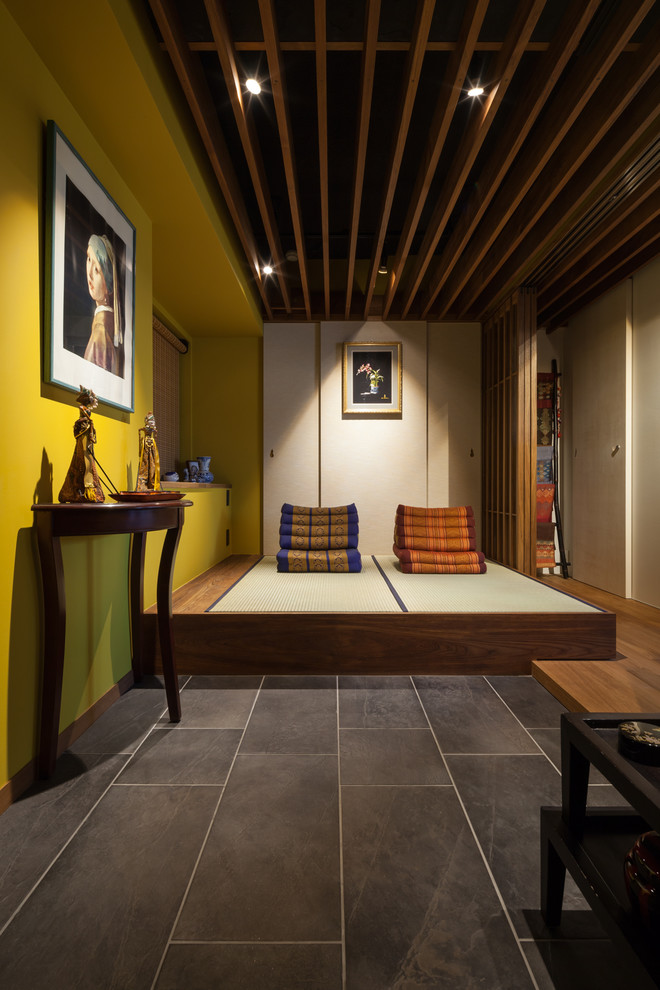 Large asian entry hall in Tokyo with yellow walls and tatami floors.