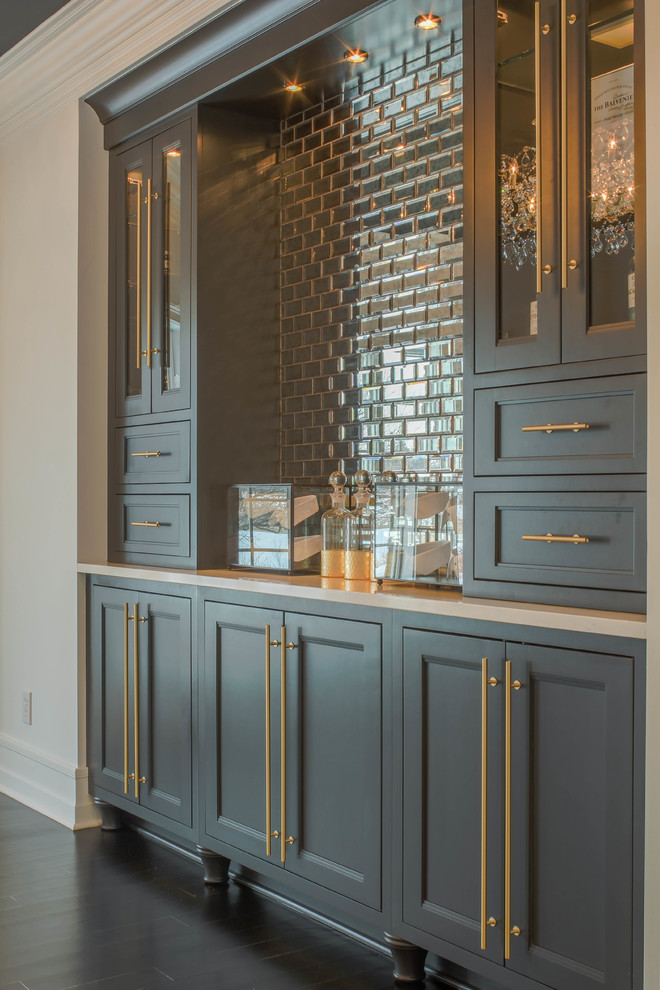 Design ideas for a mid-sized traditional single-wall home bar in Detroit with no sink, recessed-panel cabinets, grey cabinets, quartz benchtops, glass tile splashback, dark hardwood floors, brown floor and white benchtop.