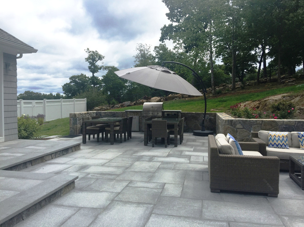 Inspiration for a large contemporary backyard patio in New York with a water feature and natural stone pavers.