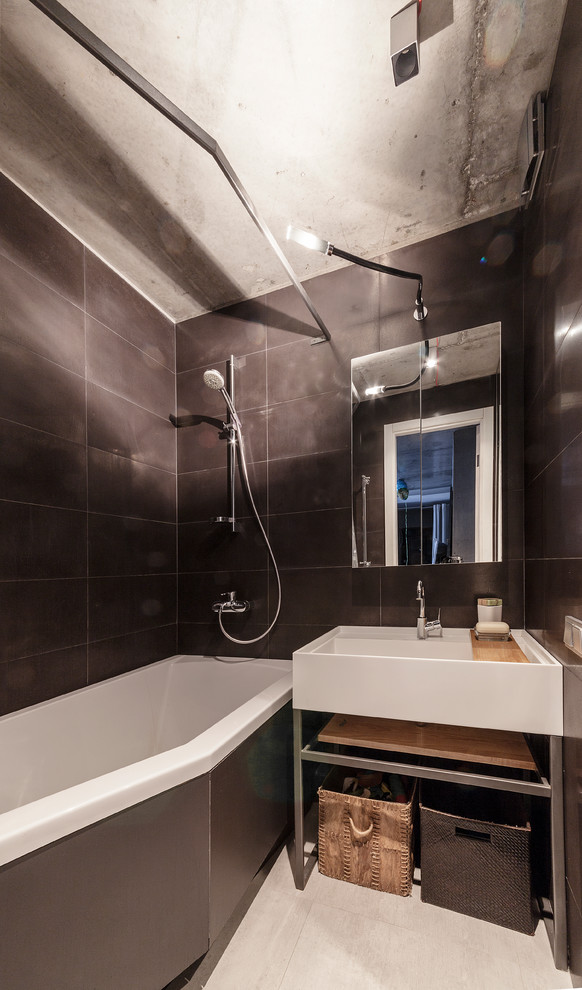 Photo of a small contemporary master bathroom in Other with a corner tub, black tile, metal tile, porcelain floors, solid surface benchtops, a shower/bathtub combo and a console sink.