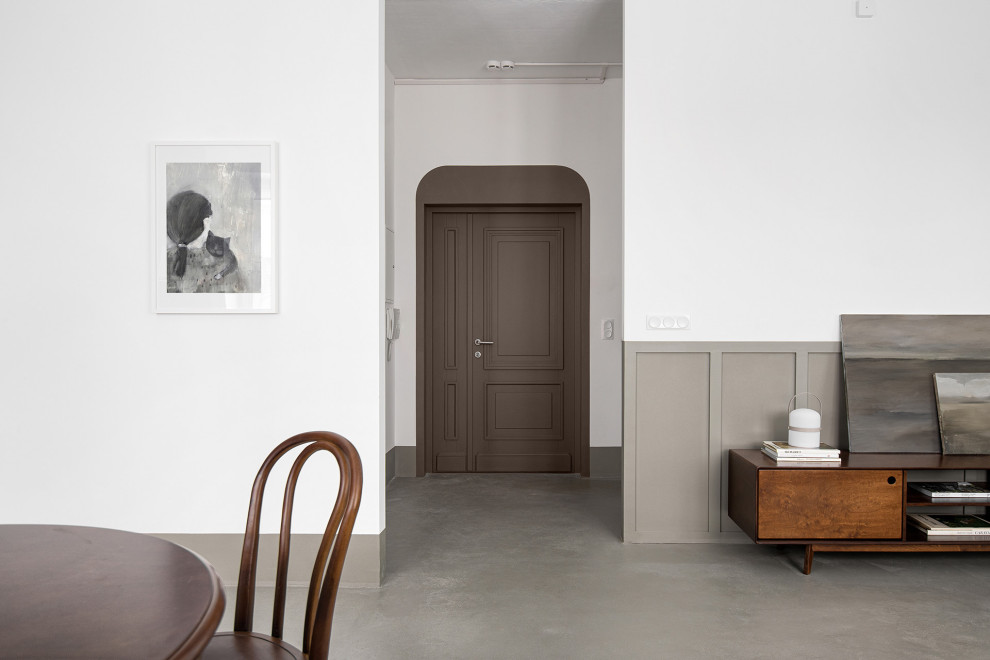 Exemple d'une petite porte d'entrée avec un mur blanc, sol en béton ciré, une porte double, une porte marron et un sol gris.