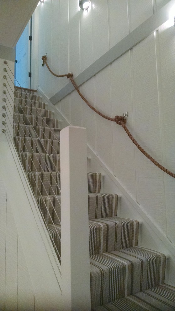 Inspiration for a mid-sized beach style painted wood straight staircase in DC Metro with painted wood risers and cable railing.