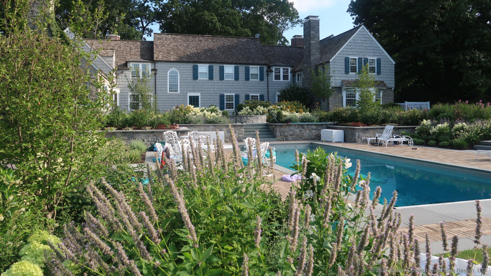 Inspiration for a mid-sized traditional backyard rectangular pool in New York with with a pool and brick pavers.