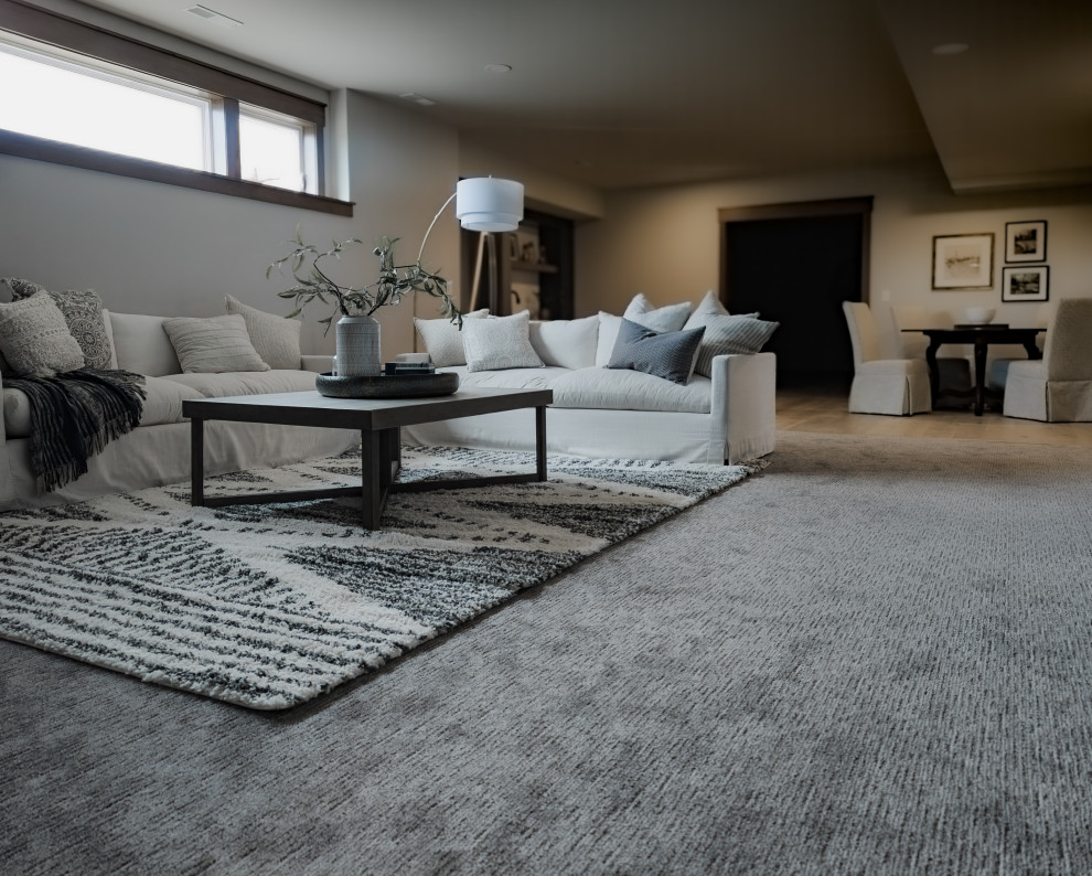 Transitional look-out carpeted and gray floor basement photo with a bar