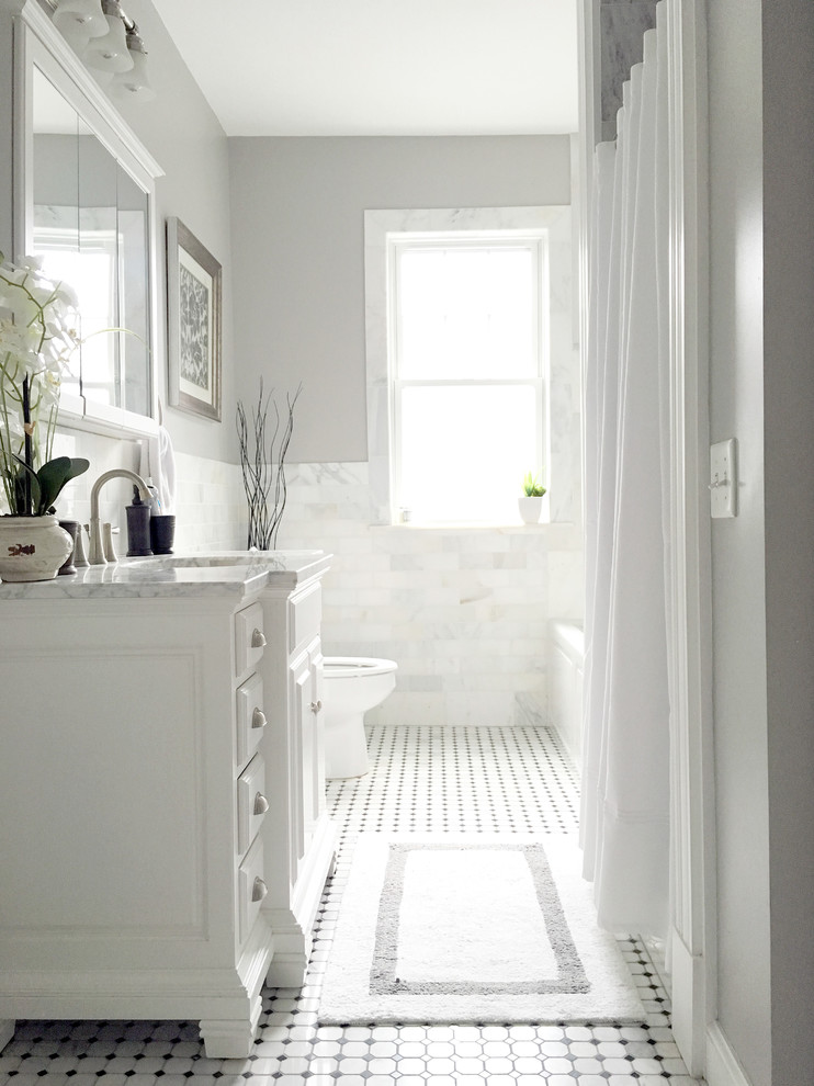 Photo of a mid-sized traditional bathroom in Boston with raised-panel cabinets, white cabinets, marble benchtops, black and white tile, ceramic tile, grey walls and ceramic floors.