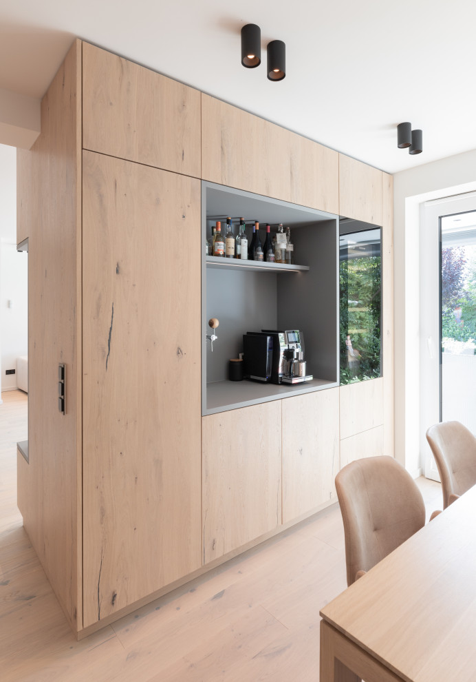 Photo of a small scandinavian single-wall home bar in Other with no sink, flat-panel cabinets, medium wood cabinets, wood benchtops, grey splashback, timber splashback, light hardwood floors, beige floor and grey benchtop.