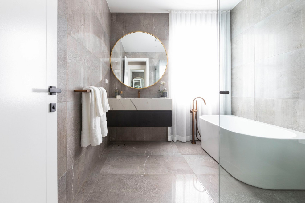 This is an example of a contemporary master bathroom in Sydney with flat-panel cabinets, a freestanding tub, a curbless shower, an integrated sink, marble benchtops, multi-coloured floor, a hinged shower door, a single vanity and a floating vanity.
