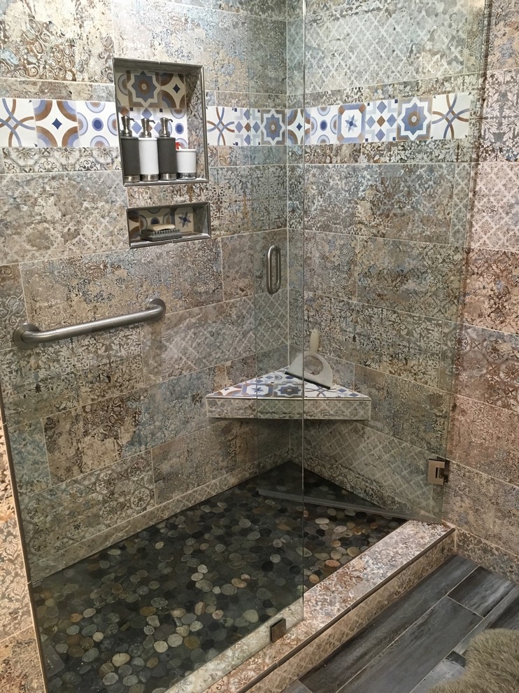 Photo of a mid-sized mediterranean 3/4 bathroom in Miami with shaker cabinets, white cabinets, an alcove shower, multi-coloured tile, cement tile, multi-coloured walls, medium hardwood floors, an undermount sink, solid surface benchtops, grey floor, a hinged shower door and black benchtops.