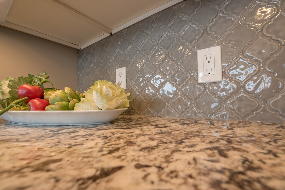 Eat-in kitchen - mid-sized transitional l-shaped medium tone wood floor and brown floor eat-in kitchen idea in Minneapolis with an undermount sink, shaker cabinets, white cabinets, granite countertops, beige backsplash, ceramic backsplash, stainless steel appliances and an island