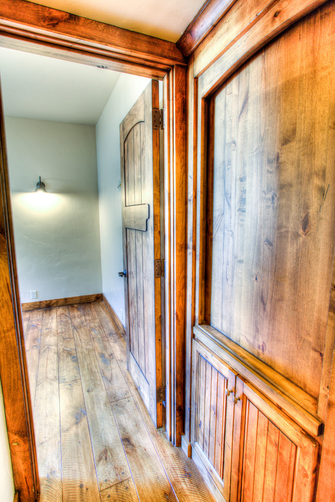 Example of a small mountain style medium tone wood floor hallway design with beige walls
