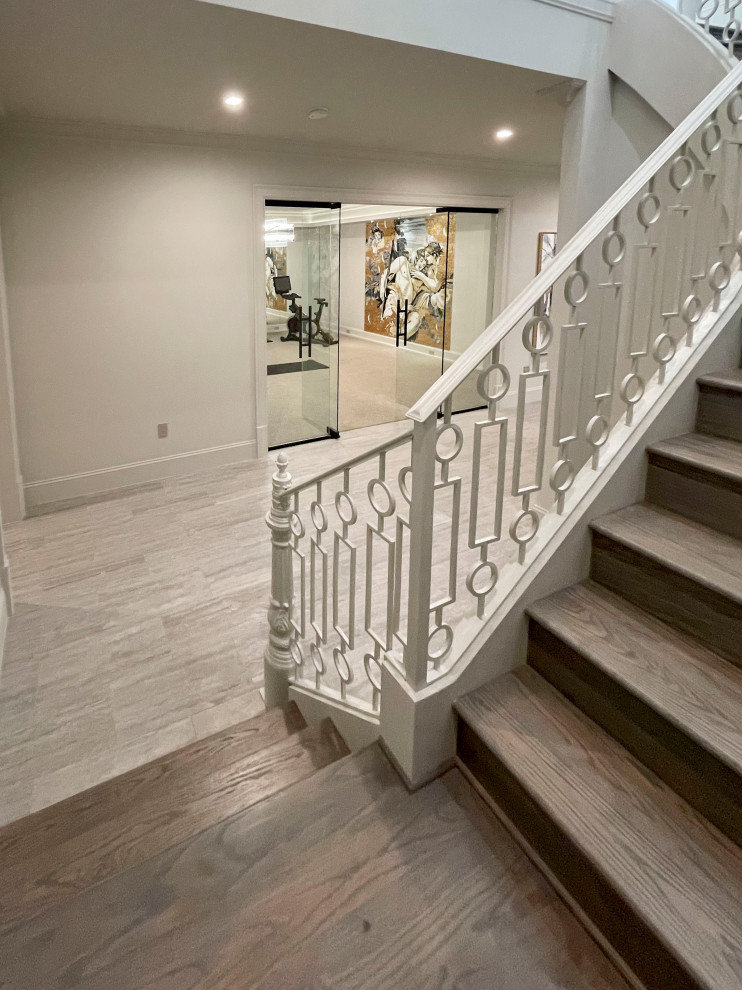 Expansive transitional wood floating staircase in DC Metro with wood risers, metal railing and panelled walls.