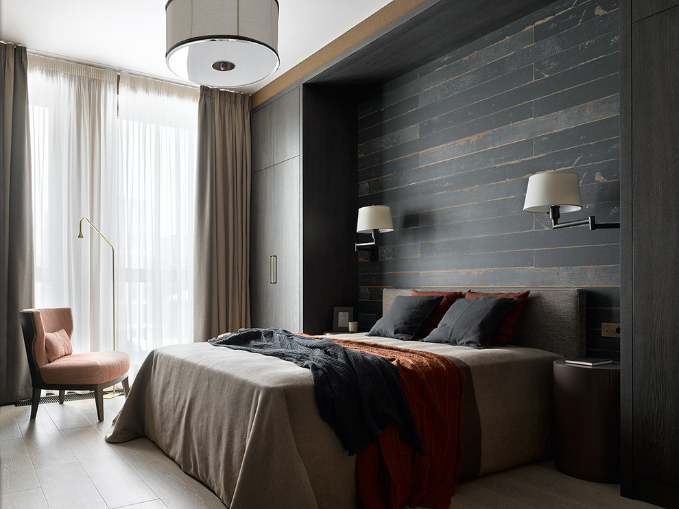 Photo of a contemporary master bedroom in Moscow with black walls, light hardwood floors and beige floor.