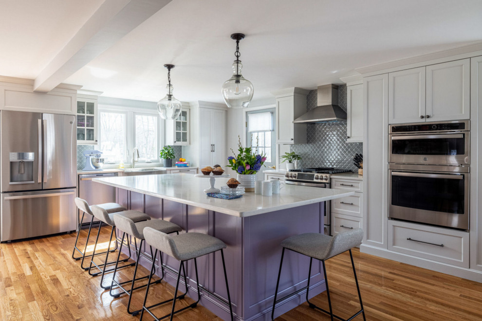 Design ideas for a traditional l-shaped kitchen in Boston with a belfast sink, shaker cabinets, purple cabinets, engineered stone countertops, grey splashback, ceramic splashback, stainless steel appliances, light hardwood flooring, an island and white worktops.