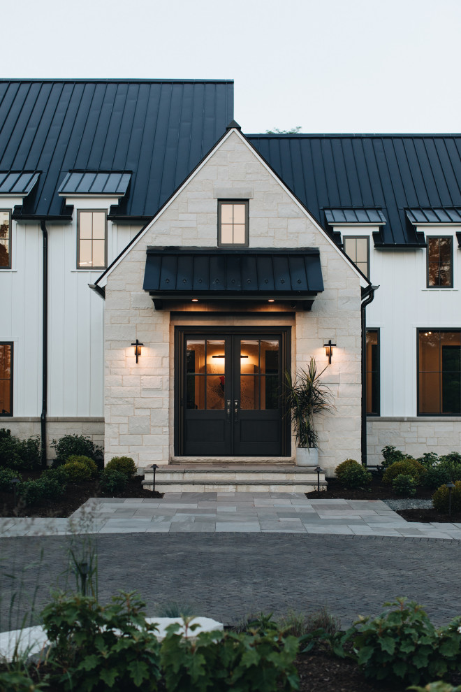 Inspiration for a large transitional white house exterior in Chicago with a black roof and a metal roof.