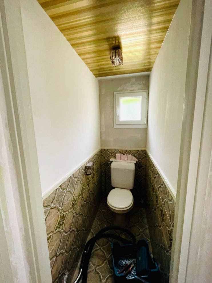 Kleine Retro Gästetoilette mit Toilette mit Aufsatzspülkasten, braunen Fliesen, Keramikfliesen, weißer Wandfarbe, Keramikboden, braunem Boden und Tapetendecke in Dijon
