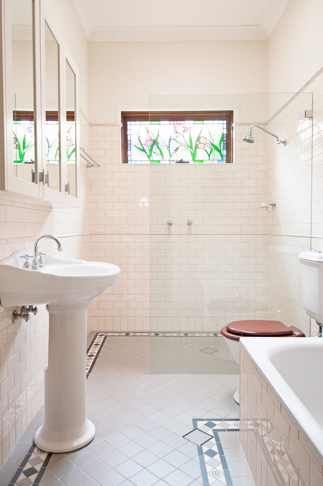 Photo of a large traditional master bathroom in Sydney with a pedestal sink, a drop-in tub, a curbless shower, a two-piece toilet, subway tile, beige walls, ceramic floors and white tile.