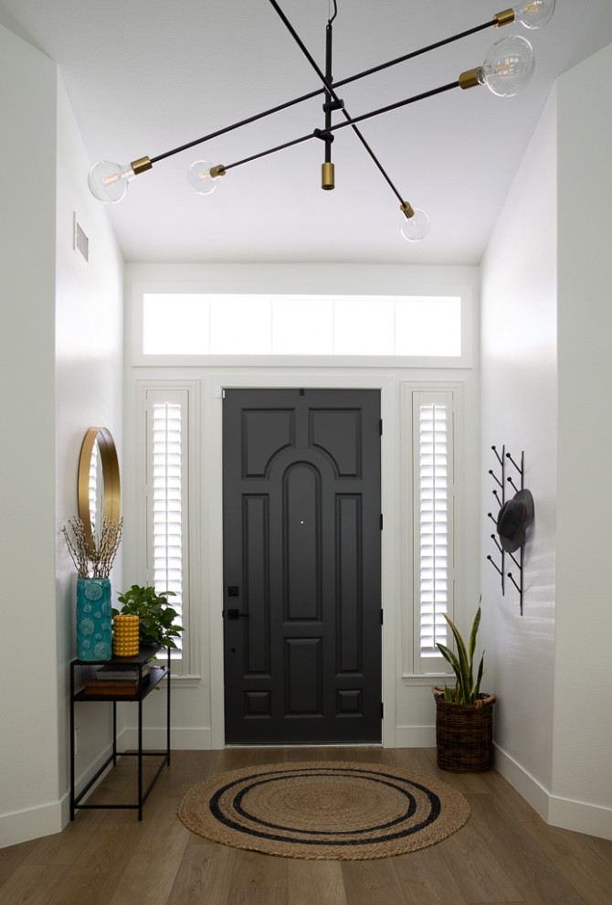 Inspiration for a large foyer in Las Vegas with white walls, vinyl flooring, a single front door, a black front door, beige floors and a vaulted ceiling.