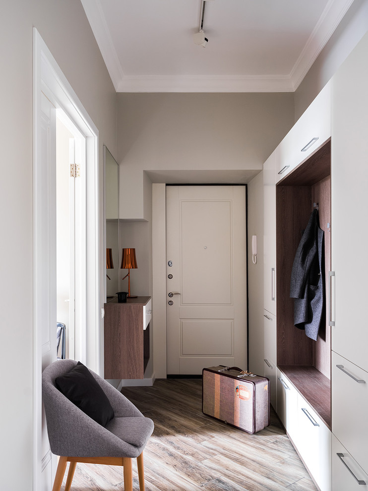 На фото: входная дверь в современном стиле с серыми стенами, одностворчатой входной дверью и белой входной дверью с