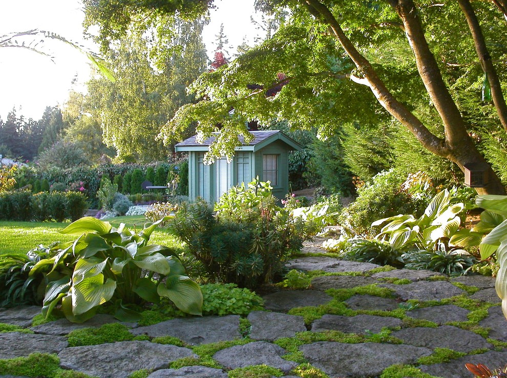 Photo of a large traditional backyard shaded garden in Seattle with natural stone pavers.