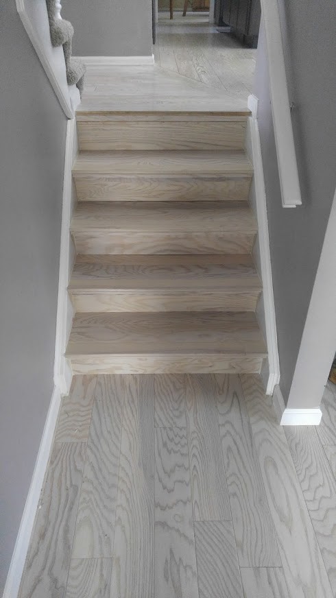 This is an example of a small transitional wood staircase in Denver with wood risers and wood railing.