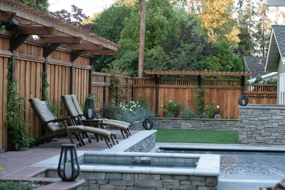Inspiration for a mid-sized transitional backyard rectangular lap pool in San Francisco with natural stone pavers and a hot tub.