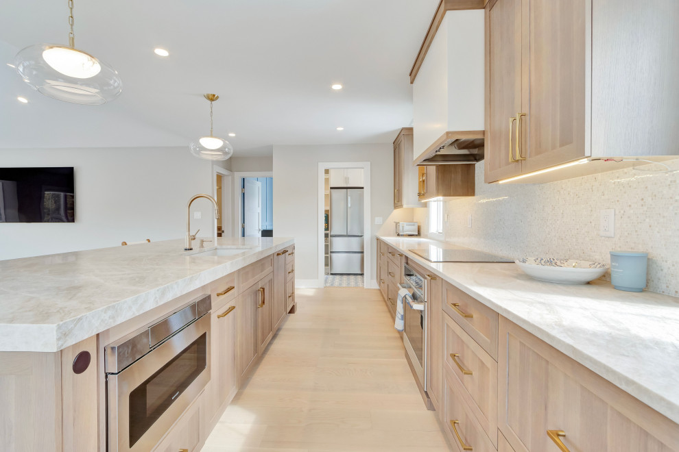 Eat-in kitchen - large galley light wood floor, brown floor and vaulted ceiling eat-in kitchen idea with shaker cabinets, light wood cabinets, white backsplash, ceramic backsplash, stainless steel appliances, an island and gray countertops