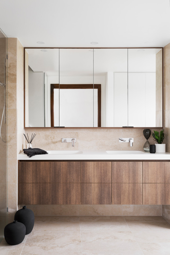 This is an example of a mid-sized contemporary master bathroom in Melbourne with flat-panel cabinets, dark wood cabinets, beige walls, an integrated sink, beige floor, a drop-in tub, an alcove shower, a two-piece toilet, ceramic tile, ceramic floors, laminate benchtops, an open shower and white benchtops.
