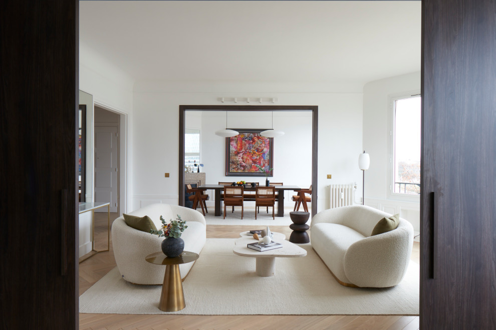 Idée de décoration pour un salon design fermé avec un mur blanc, parquet clair et un sol beige.