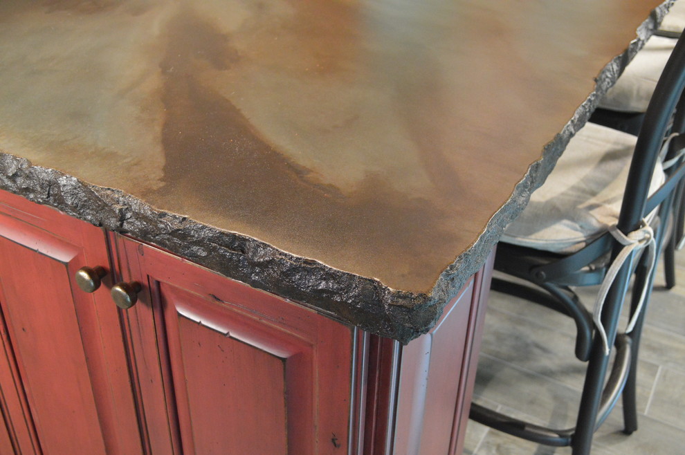 Example of a large mountain style galley porcelain tile home design design in Columbus with an undermount sink, raised-panel cabinets, distressed cabinets, concrete countertops and an island