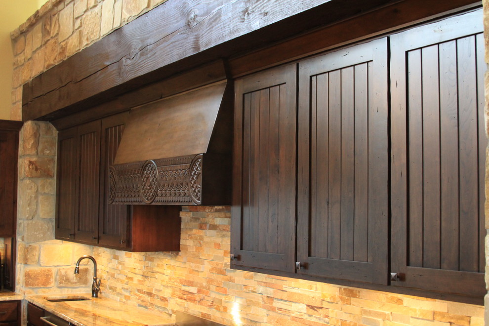 Inspiration for a rustic galley concrete floor open concept kitchen remodel in Austin with a farmhouse sink, beaded inset cabinets, dark wood cabinets, granite countertops, stainless steel appliances and a peninsula