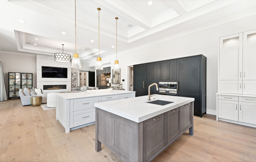 Kitchen - huge transitional u-shaped light wood floor, brown floor and coffered ceiling kitchen idea in Chicago with an undermount sink, shaker cabinets, gray cabinets, quartz countertops, white backsplash, quartz backsplash, stainless steel appliances, two islands and white countertops