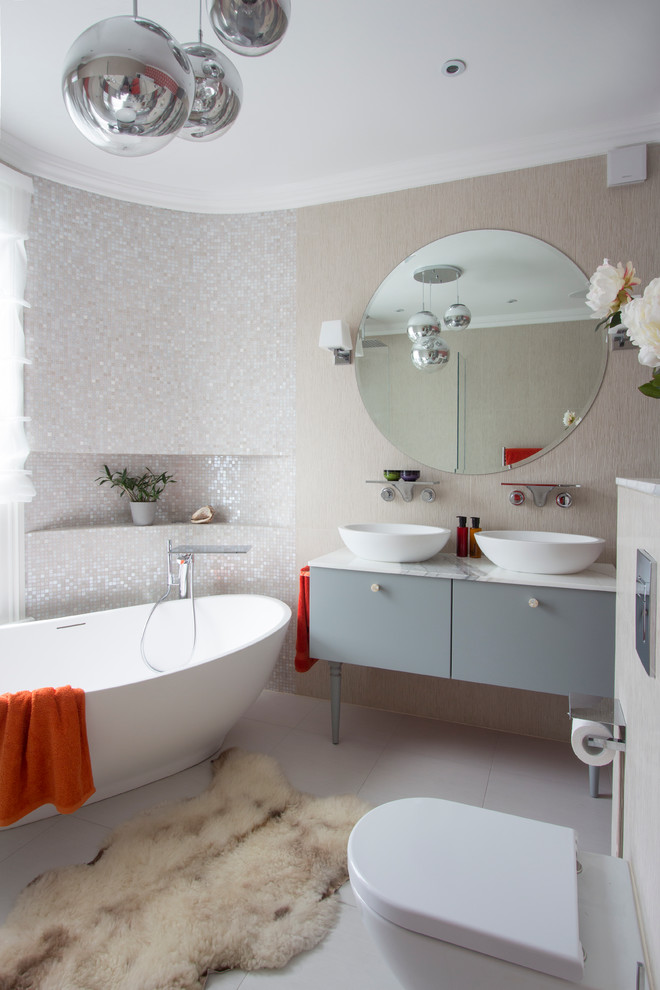 Photo of a large contemporary master bathroom in London with a freestanding tub.