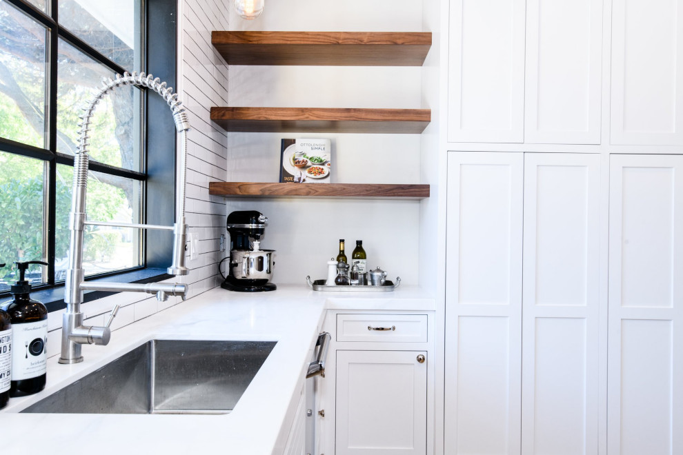 Inspiration for a mid-sized country u-shaped separate kitchen in San Francisco with shaker cabinets, white cabinets, quartz benchtops, white splashback, subway tile splashback, stainless steel appliances, light hardwood floors, with island, brown floor and white benchtop.