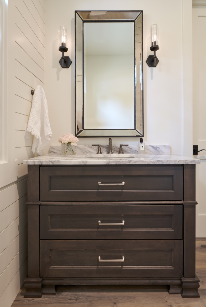 Inspiration for a medium sized country cloakroom in Seattle with recessed-panel cabinets, brown cabinets, white walls, light hardwood flooring, a submerged sink, quartz worktops, brown floors, white worktops, a built in vanity unit and tongue and groove walls.