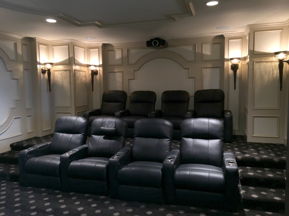 Photo of an expansive transitional enclosed home theatre in Kansas City with beige walls, carpet, a projector screen and multi-coloured floor.