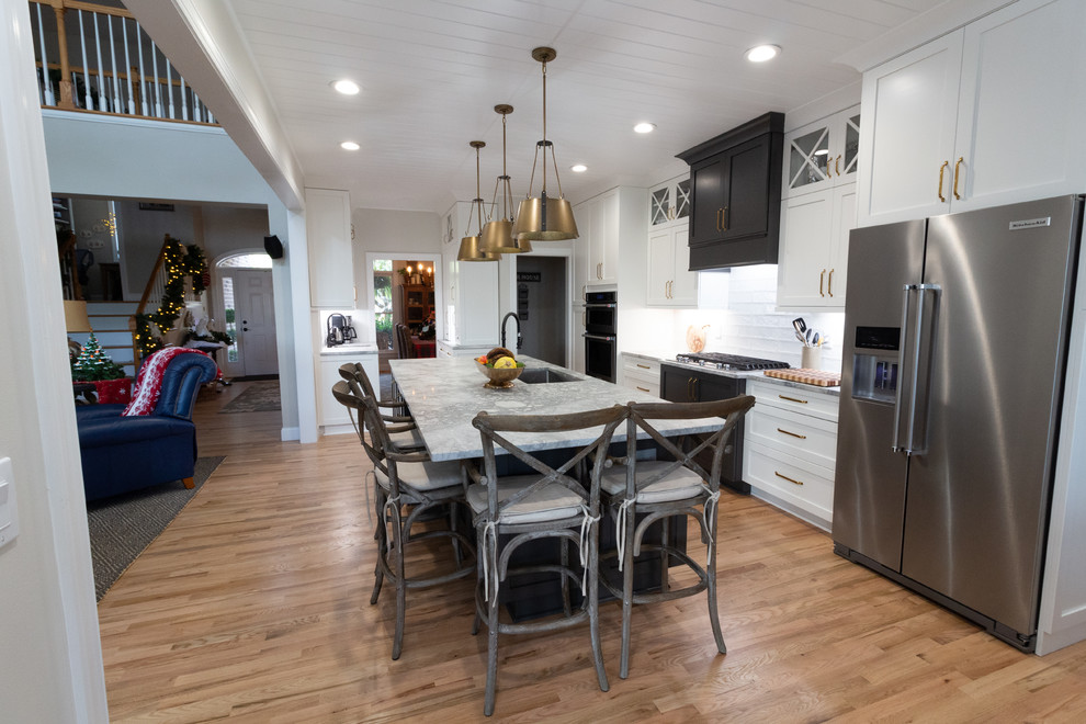 Large l-shaped eat-in kitchen photo with shaker cabinets, white cabinets, granite countertops, an island and white countertops