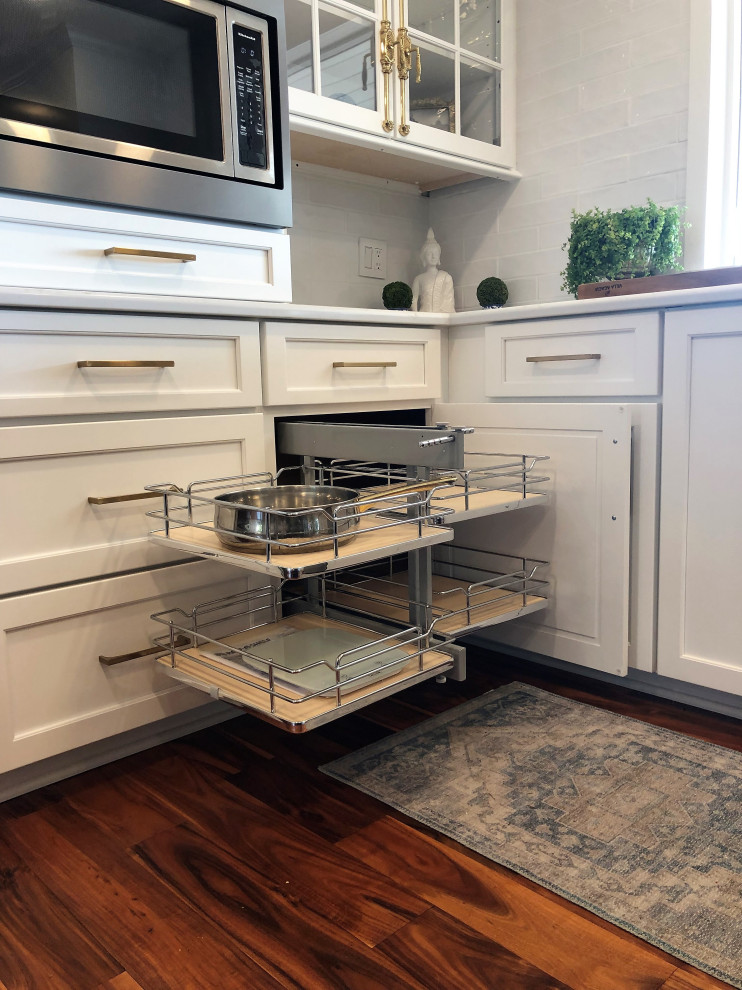 Mid-sized transitional l-shaped medium tone wood floor and brown floor kitchen pantry photo with an undermount sink, flat-panel cabinets, blue cabinets, quartz countertops, white backsplash, subway tile backsplash, stainless steel appliances, an island and gray countertops