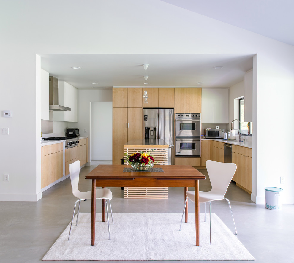 Photo of a small contemporary kitchen/dining combo in Orange County with concrete floors, white walls and no fireplace.