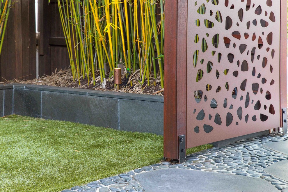 Photo of a contemporary front yard partial sun garden for summer in Brisbane with a garden path and concrete pavers.