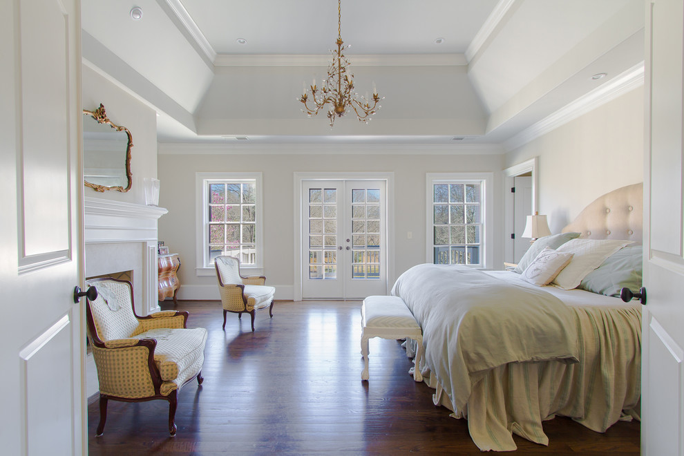 Photo of a traditional bedroom in Atlanta with beige walls, dark hardwood floors and a standard fireplace.
