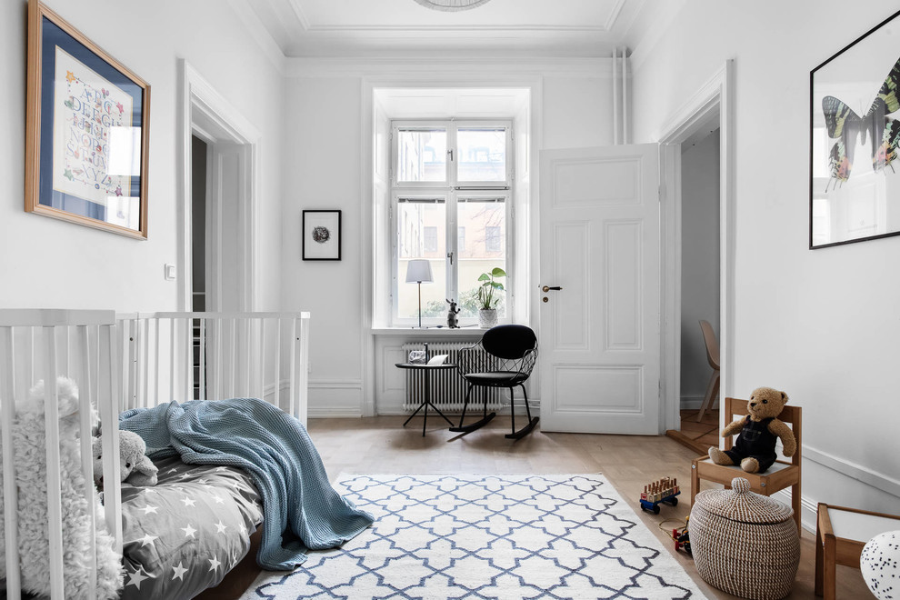 Inspiration for a mid-sized scandinavian kids' room for boys in Stockholm with white walls, light hardwood floors and beige floor.