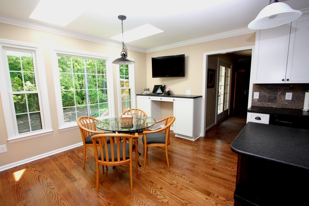 Eat-in kitchen - mid-sized transitional l-shaped medium tone wood floor eat-in kitchen idea in Raleigh with an undermount sink, shaker cabinets, white cabinets, granite countertops, gray backsplash, stone tile backsplash, stainless steel appliances and an island