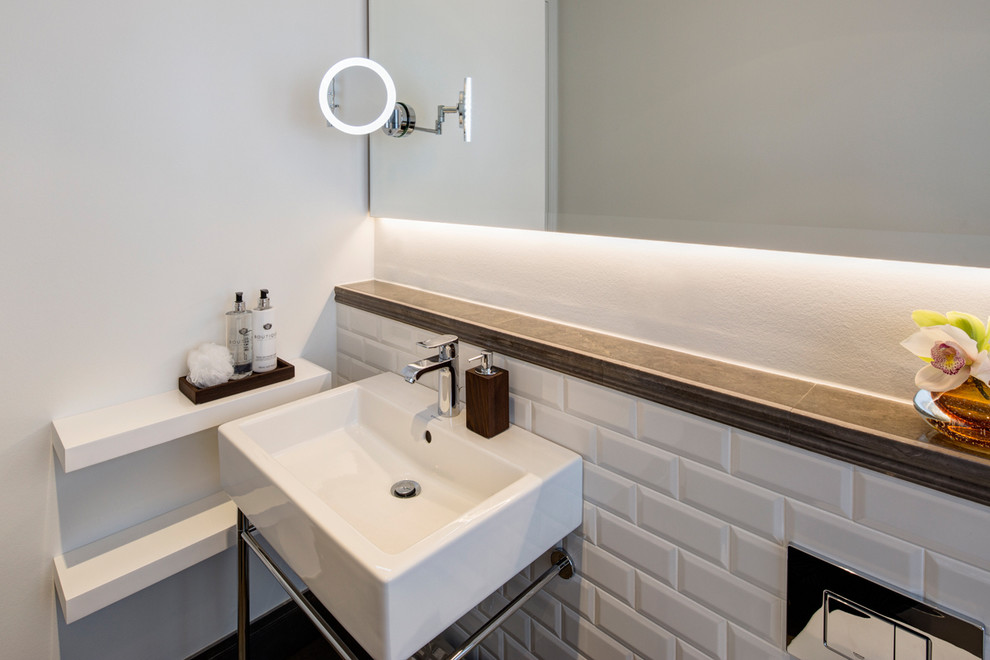Small contemporary 3/4 bathroom in Berlin with white tile, subway tile, white walls, a console sink, flat-panel cabinets, white cabinets, a drop-in tub, a curbless shower, a two-piece toilet, limestone floors, tile benchtops, grey floor and an open shower.