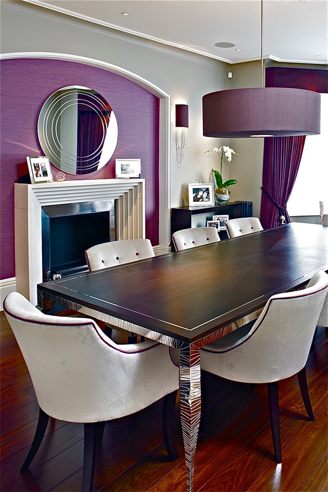 Photo of a contemporary dining room in London with purple walls and dark hardwood floors.