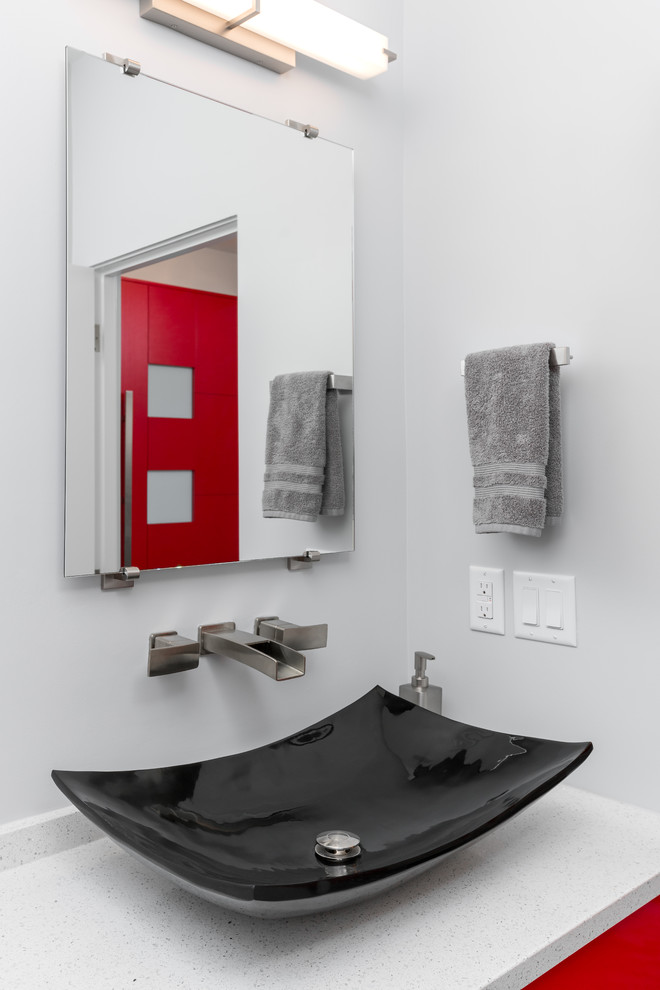 Design ideas for a small modern bathroom in Other with flat-panel cabinets, red cabinets, a two-piece toilet, gray tile, grey walls, ceramic floors, a vessel sink and grey floor.